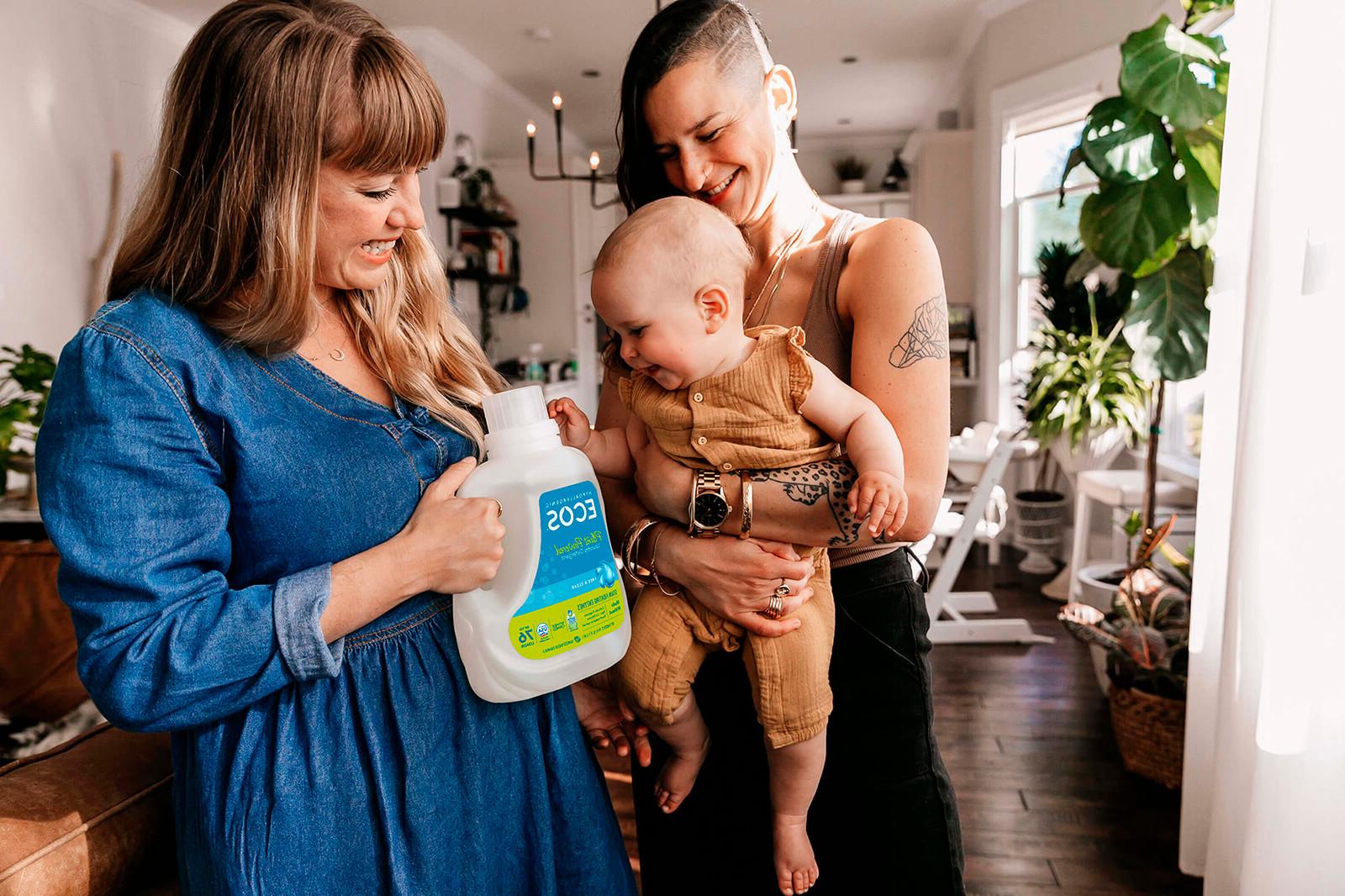 Two women holding a baby and ECOS Liquid Laundry detergent