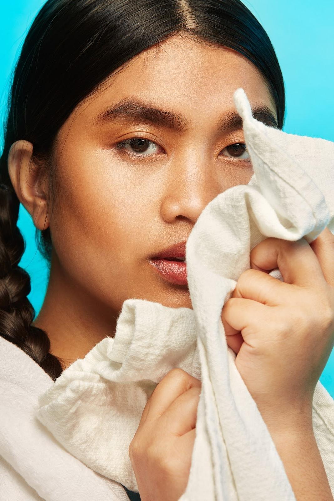 Woman Holding Clean Laundry To Face
