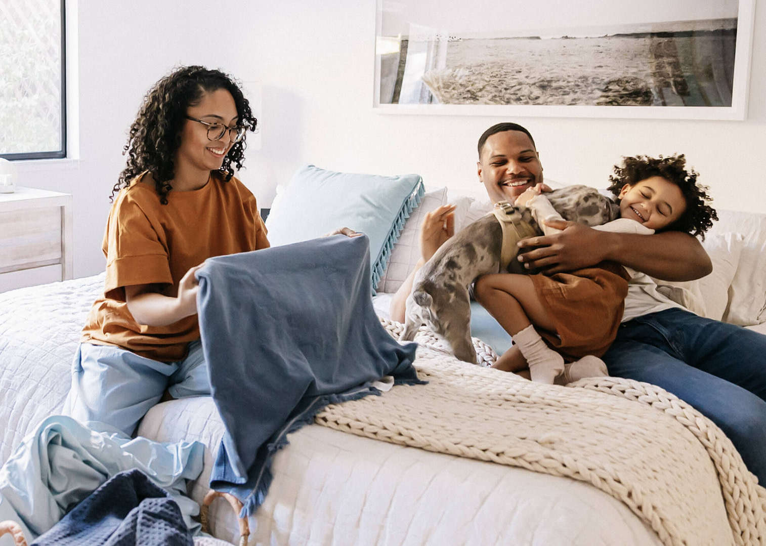 A family folding laundry and having fun