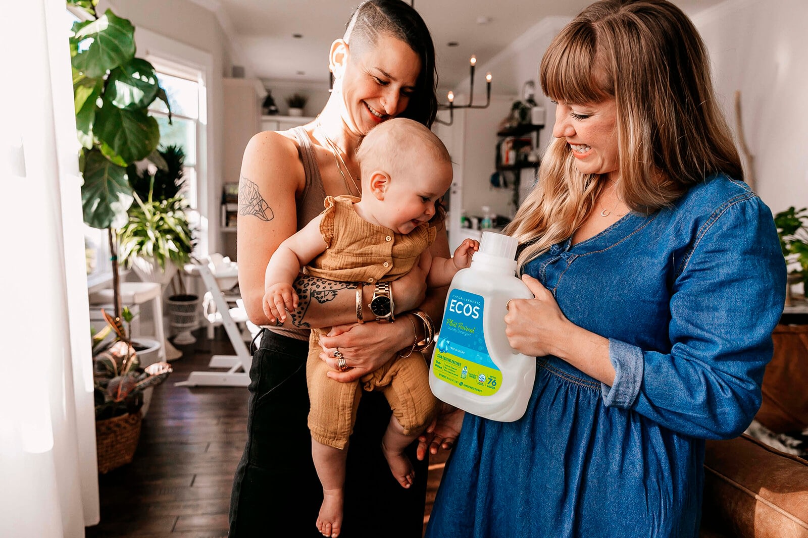 Two women holding a baby and ECOS Liquid Laundry detergent