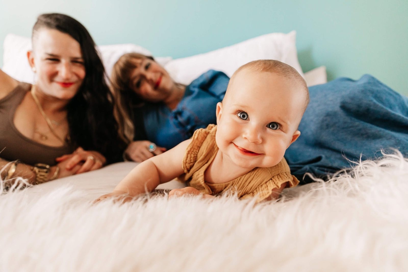 Parents With Baby On Bed