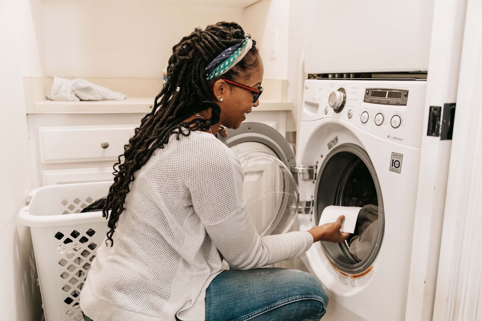 Woman Loading Laundry With Detergent Sheet