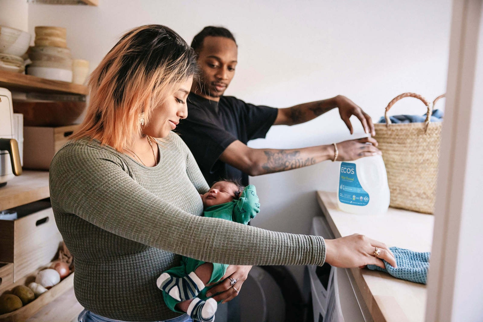 Couple With Newborn Doing Laundry