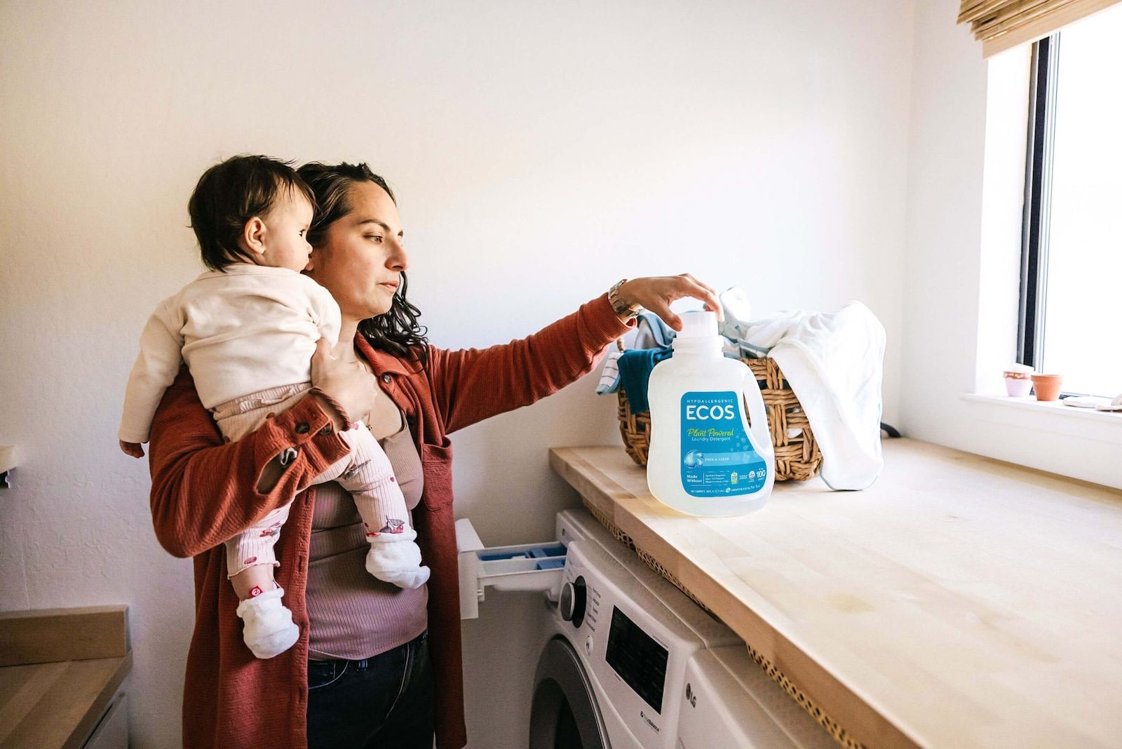 Mother Using Laundry Detergent While Holding Baby