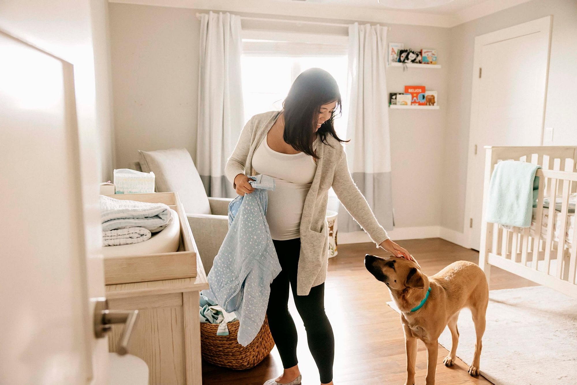 Woman Petting Dog While Putting Away Laundry