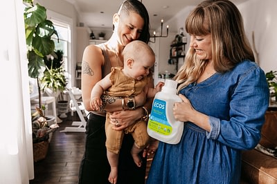 Moms and baby with laundry detergent bottle